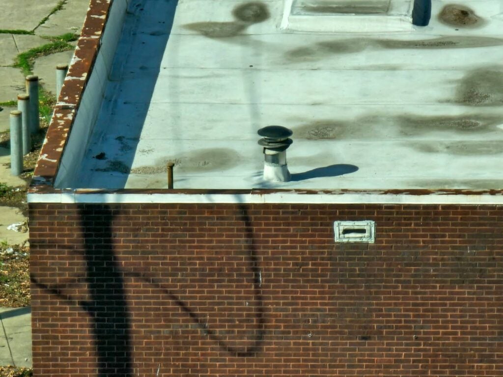 the scupper, at the external side of the parapet wall