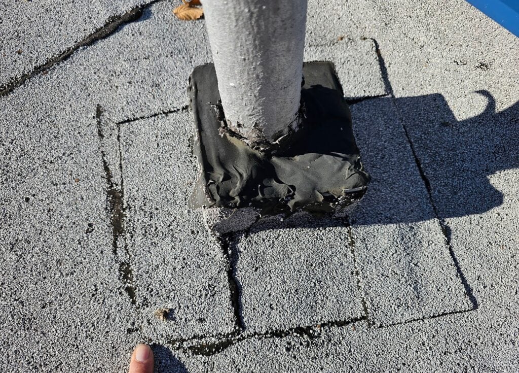 Close-up of deteriorated sealant at roof pitch pocket in DC home