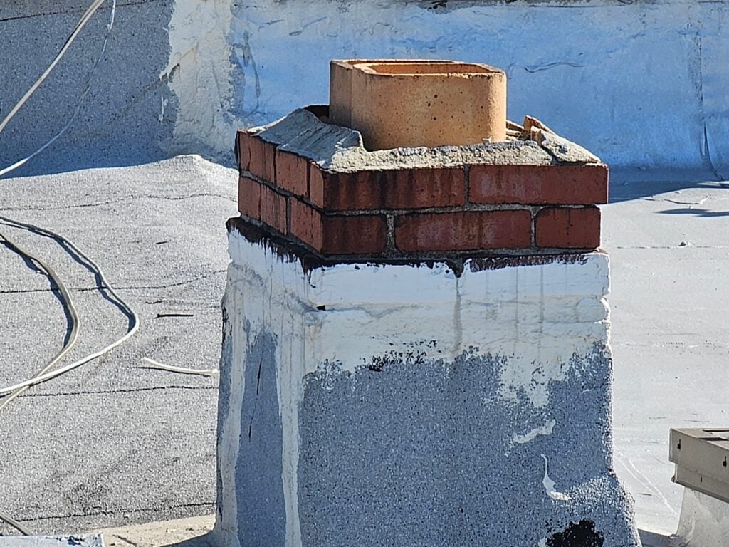 Damaged rooftop chimney flues on historic DC building