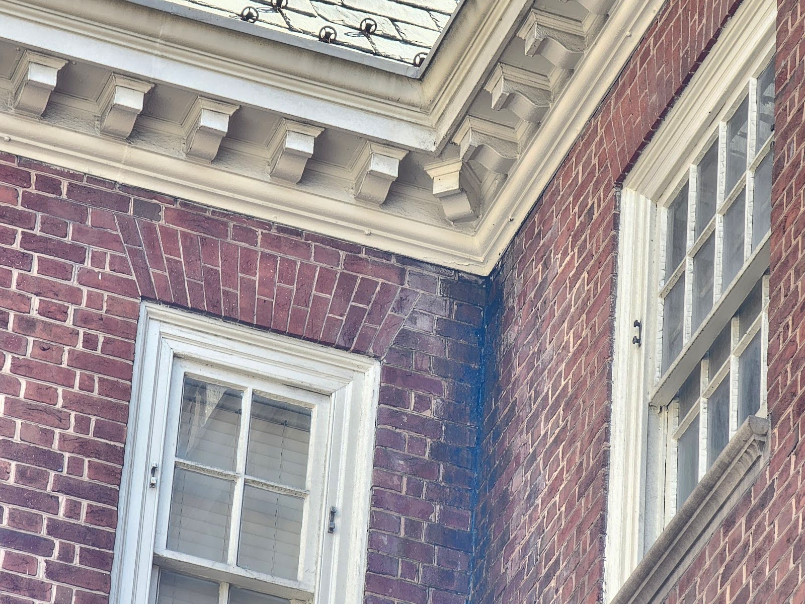 Close-up view of a damaged gutter joint leaking on an old structure