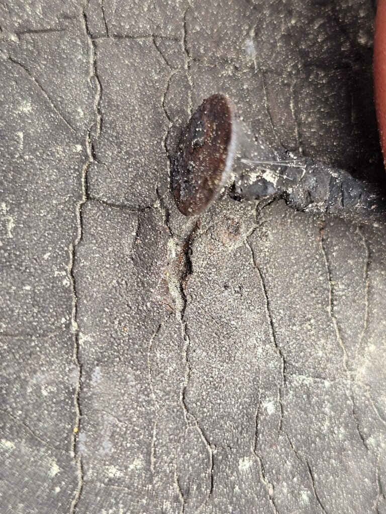 Roof damage caused by neighbor’s trash debris piled on shingles