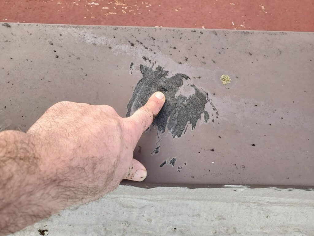 Damaged roof parapet coping before repair showing gaps and deterioration