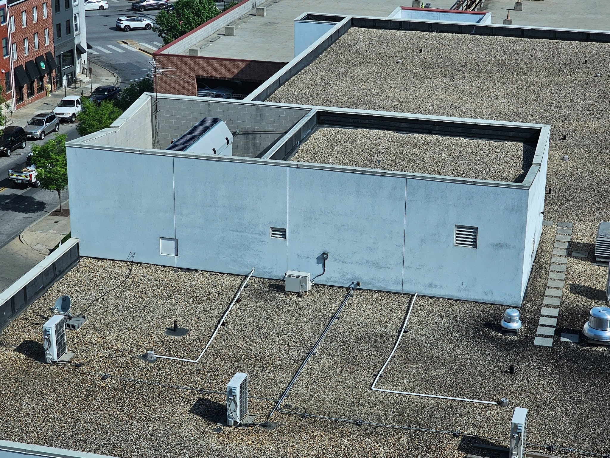 Flat roofing system with ballast stones providing membrane protection