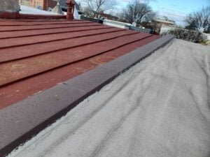 Home 16 Roof parapet coping installation detail showing protective cap along building edge