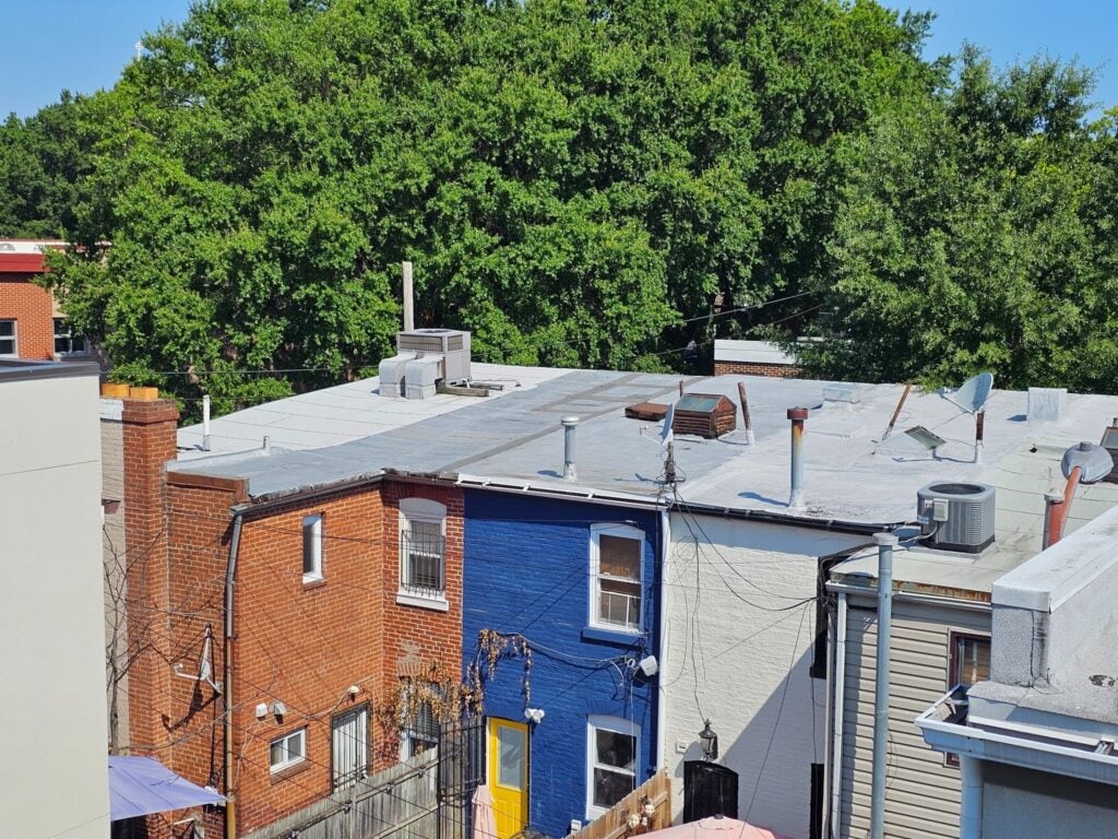 Rooftops without separating parapet walls between adjacent buildings