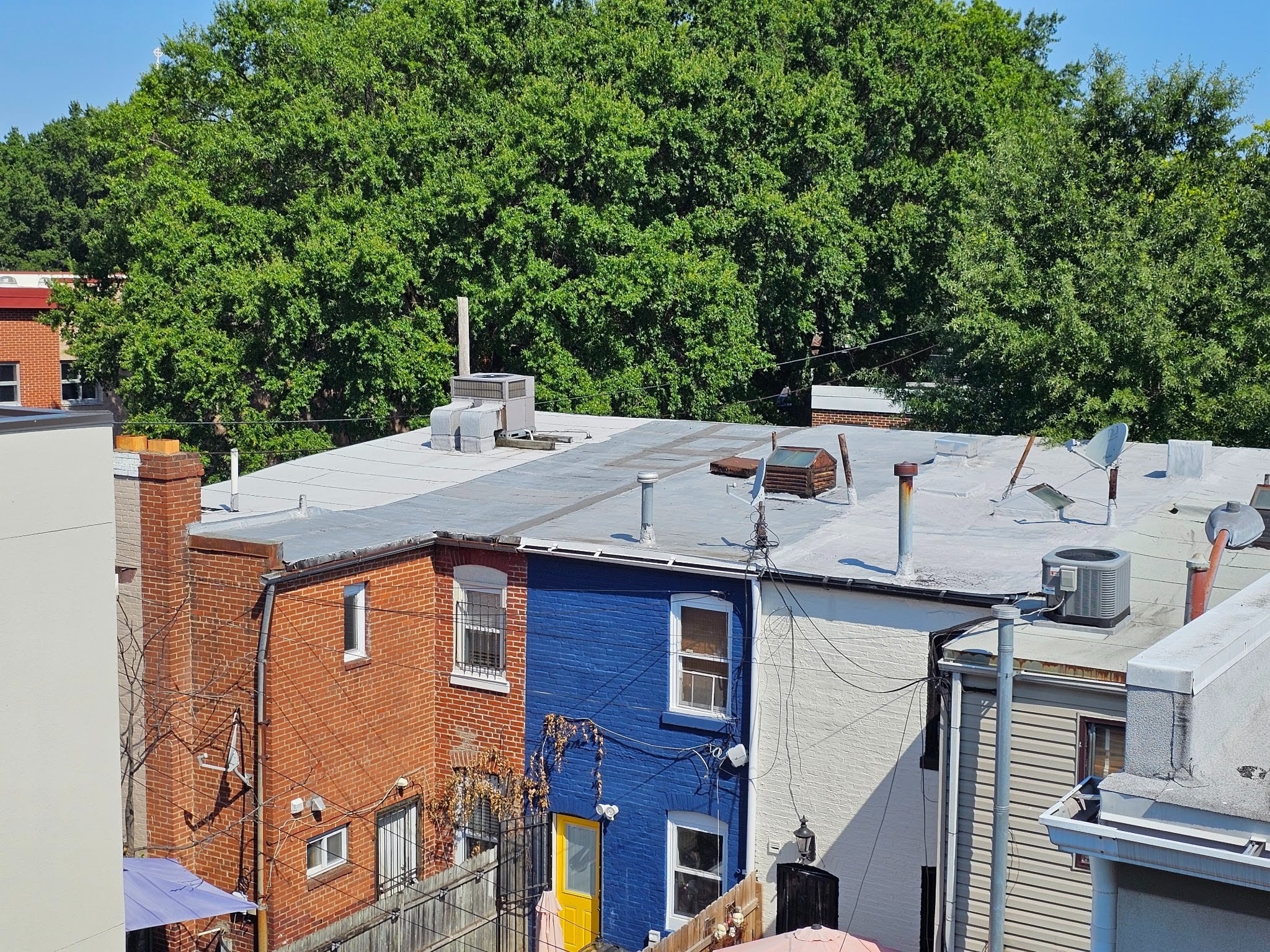 Rooftops without separating parapet walls between adjacent buildings
