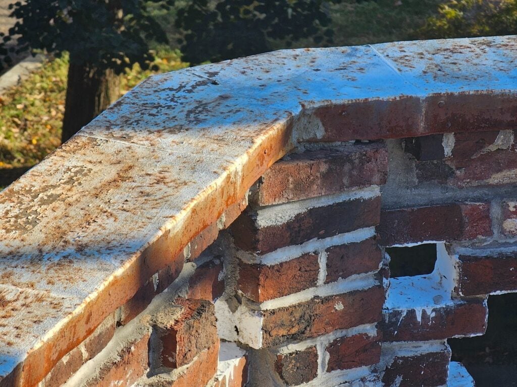 Cracked and deteriorated masonry coping with exposed joints and weather damage