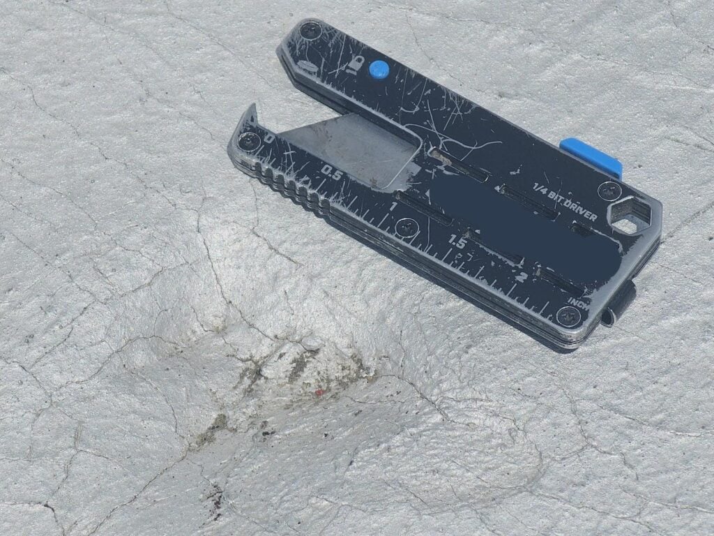 2-inch impact divot with scale reference tool on flat modbit roof, Washington DC