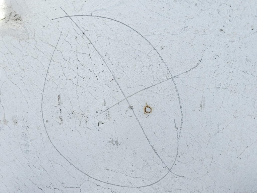 Nail pop marked with circle on aluminum-coated modbit roof membrane, DC